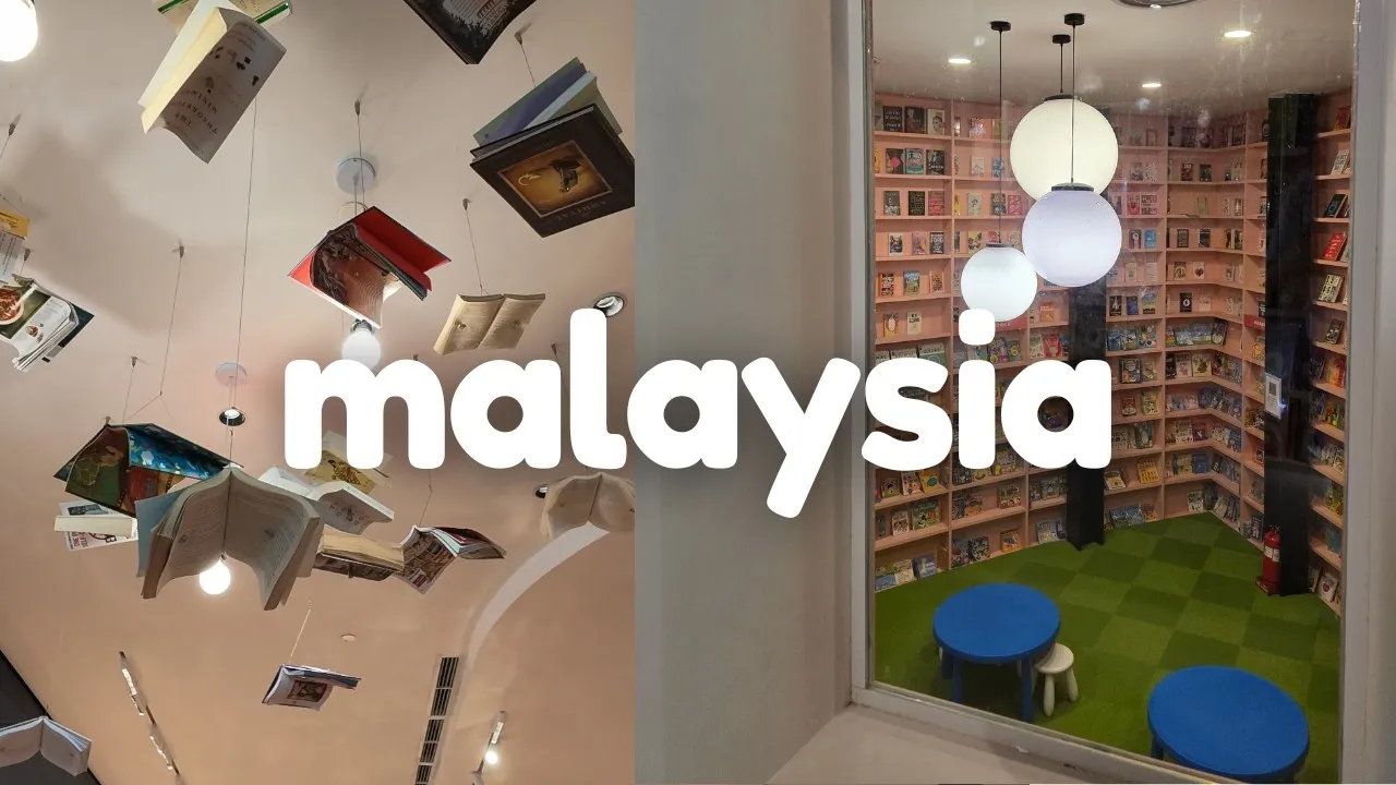 Books suspended from a bookstore ceiling beside a reading nook lit by round paper lamps.