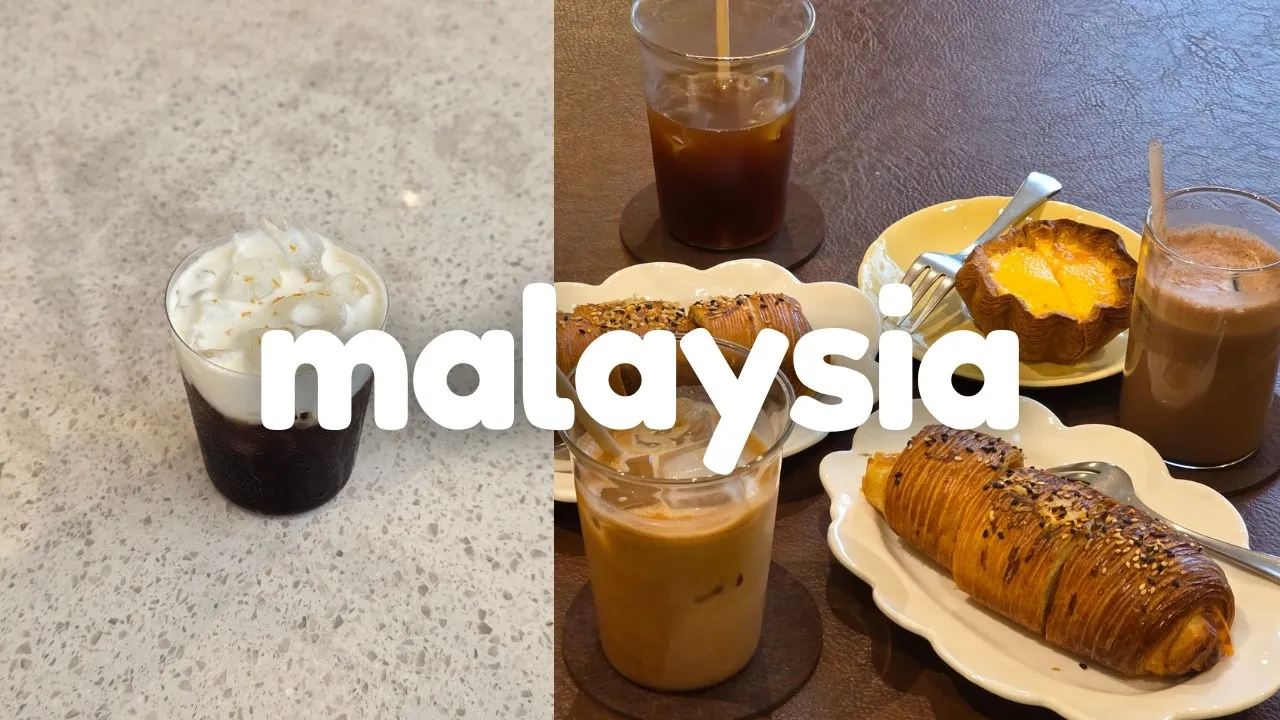 Iced coffee, cream-topped coffee, and laminated pastries on café tables in Kuala Lumpur.